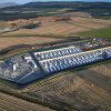 a large building with cars parked in a field